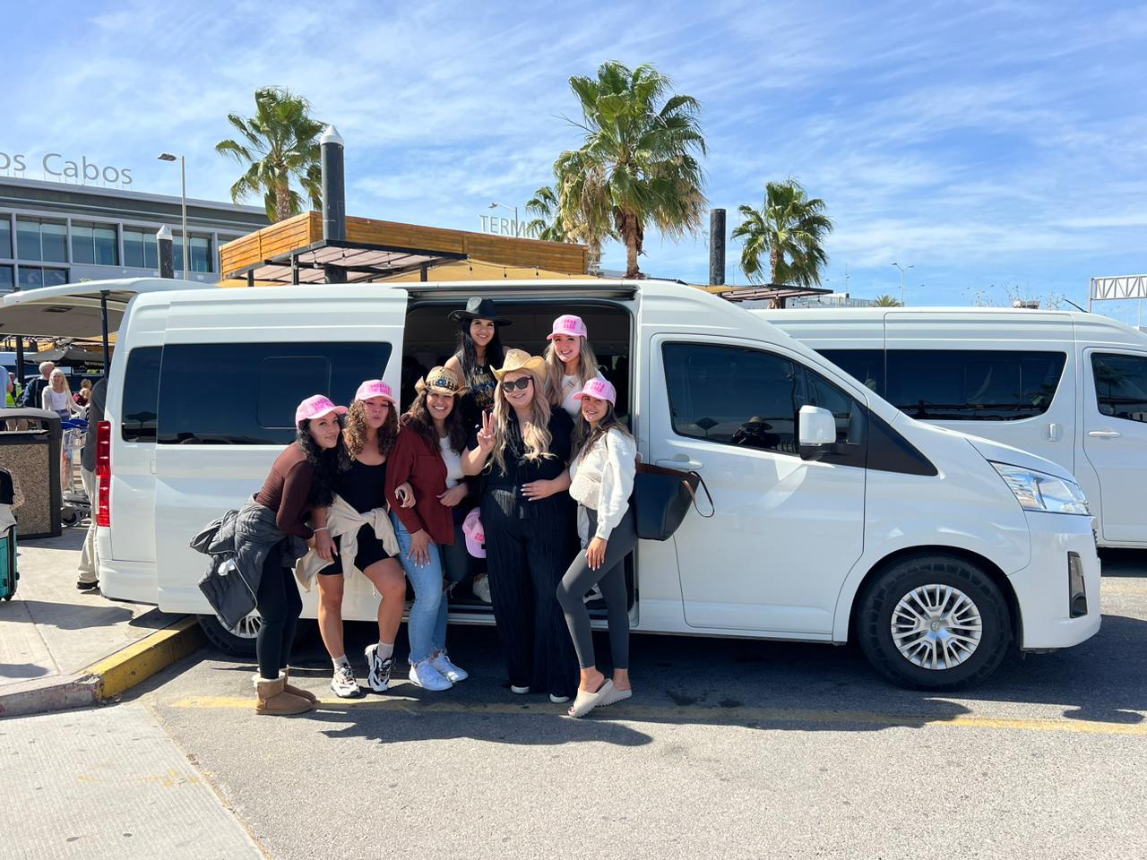 Large group of travelers boarding a big-groups shuttle van at Los Cabos International Airport