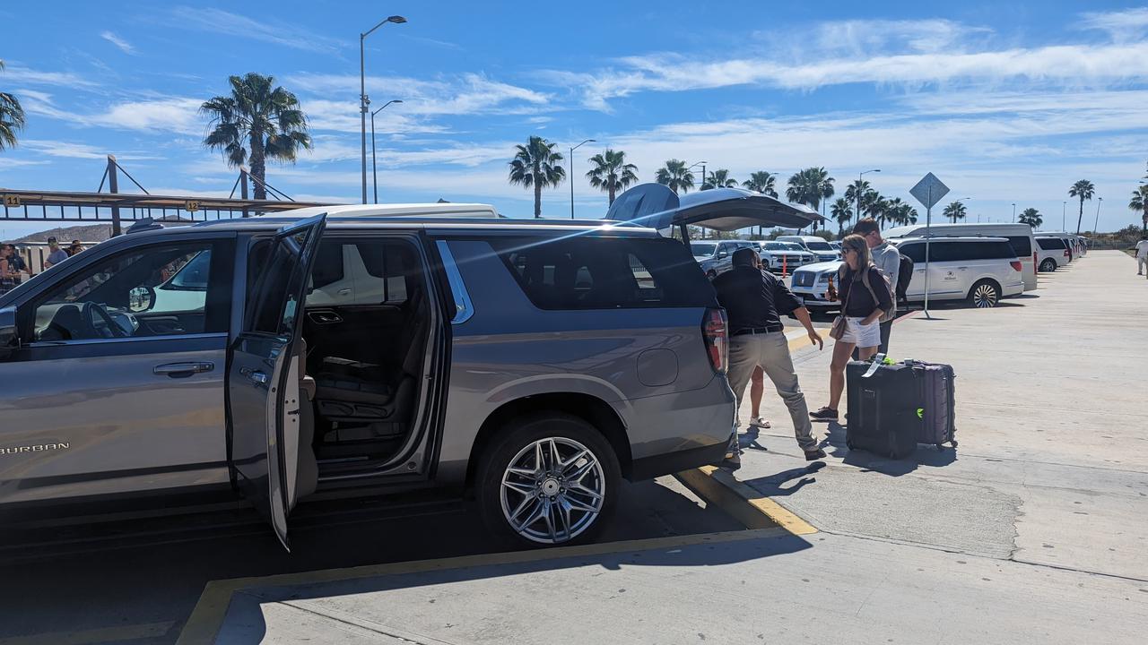 Driver loading luggage into an SUV at Los Cabos International Airport arrivals