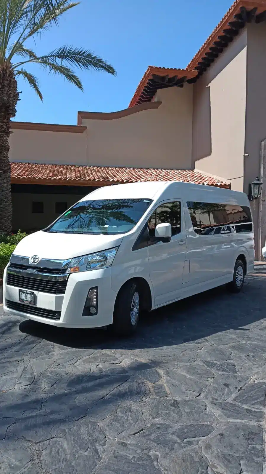 White shared shuttle van parked at a Los Cabos resort entrance